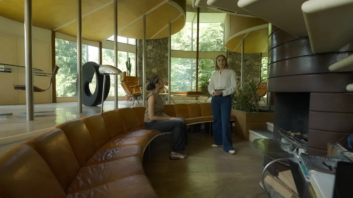 Man sieht zwei Personen in einem Rundhaus.